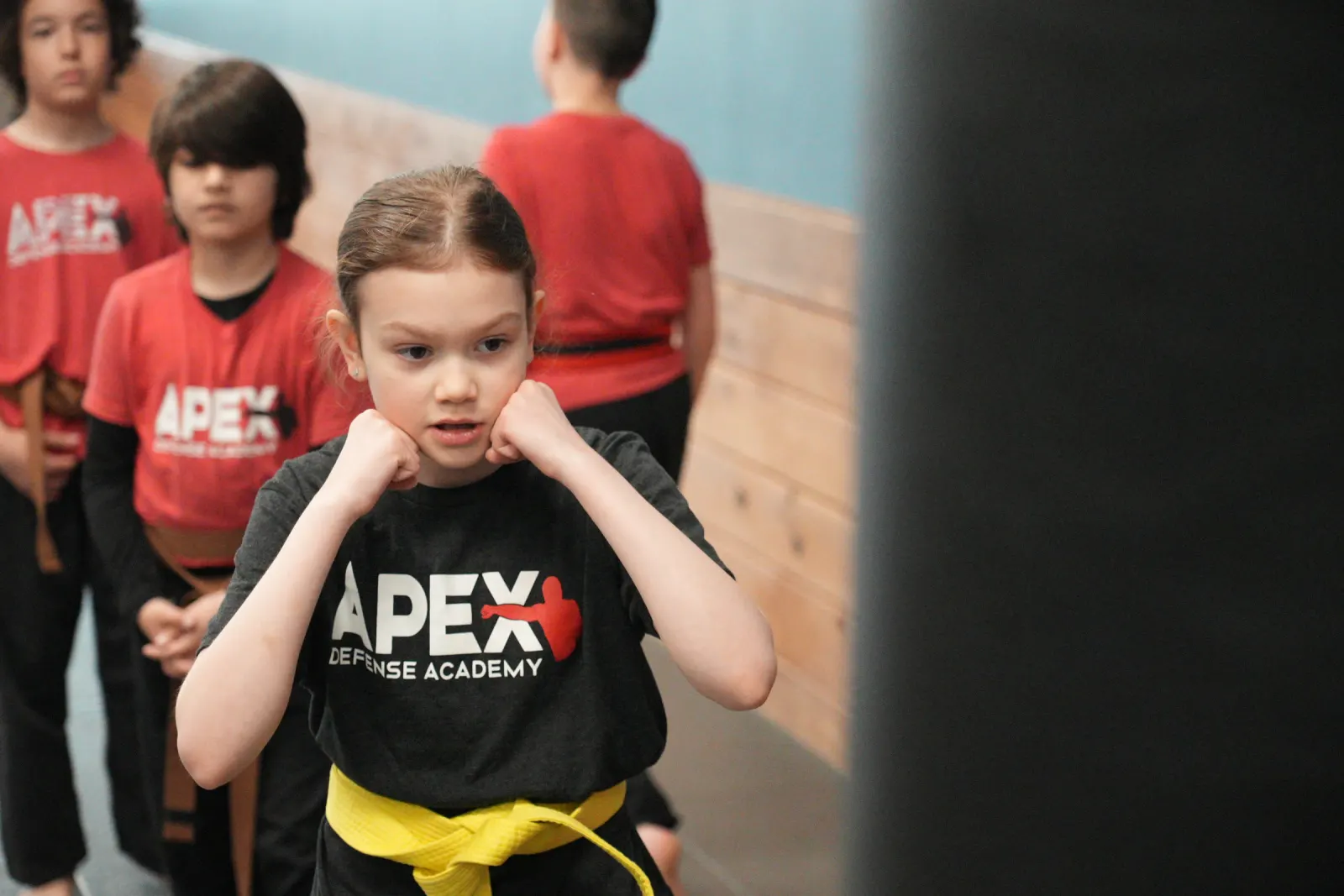 Young student in an Apex shirt holding a guard stance