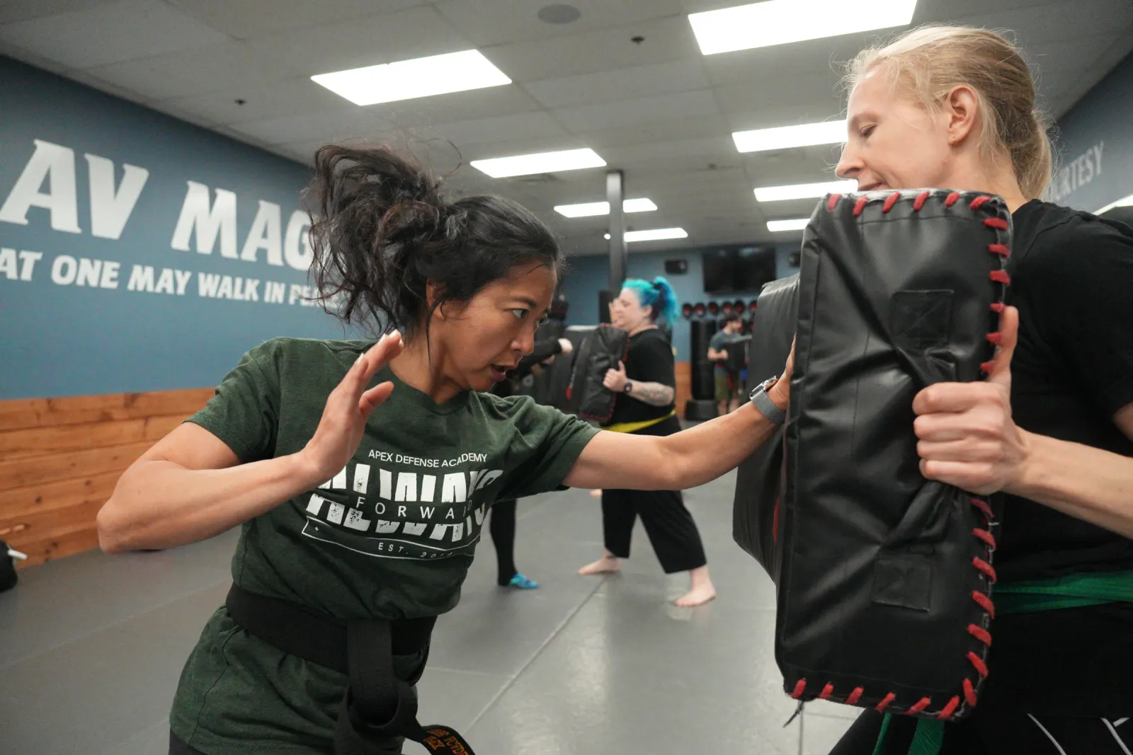 Adult student throwing an elbow into a held pad