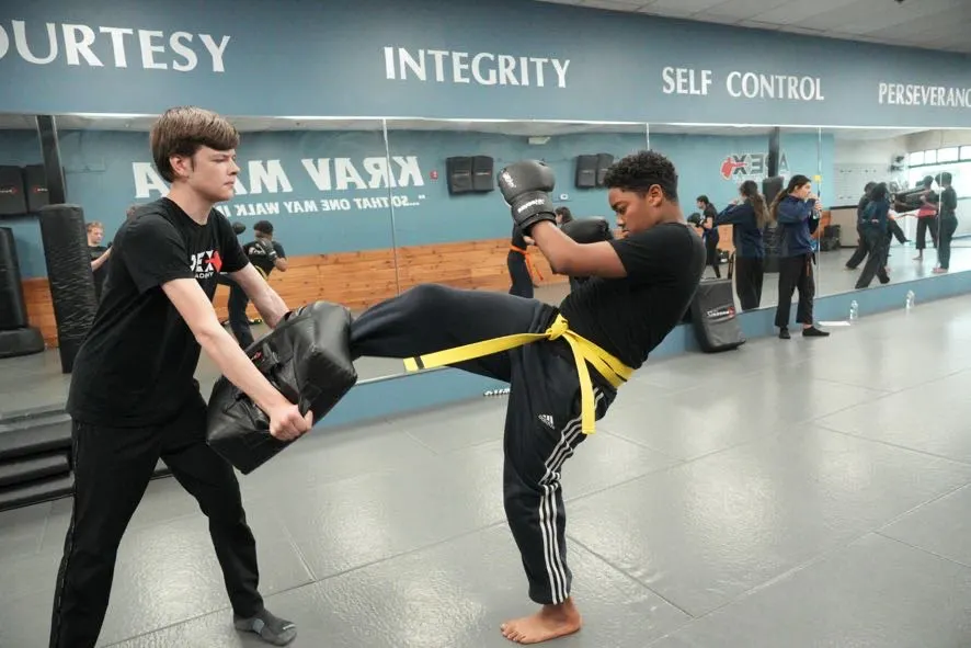 Teen throwing a kick into a held shield